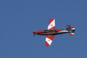 Single-engined aircraft with red-and-white livery, in flight