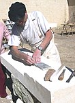 A French stonemason using a straightedge and chisels