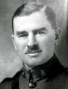 Brown-haired man with moustache. He is wearing a military uniform.