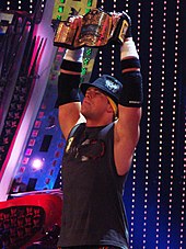 Photograph of The Real World: Back to New York cast member Mike Mizanin holding up a World Wrestling Entertainment champion belt in 2008