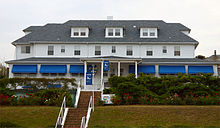 Large white building with many steps and blue awnings