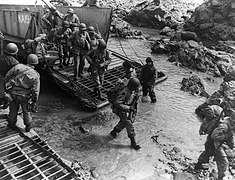 U.S Soldiers getting off their landing craft onto the rocky shores of Kiska Island