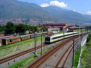 Medellín Metro train passes disused Antioquia Railway trains