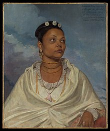 An oil painting depicting Joanna de Silva, an Indian woman, from waist up, looking into the distance. She wears delicate white clothing and has jewellery around her neck and in her hair, and a ring on her finger. An inscription states Joanna de Silva, a native / of Bengal, the faithful / and affectionate Nurse / of the Children of / Lieutenant Colonel Charles Deare / Painted by Will:m Wood 1792