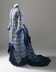 Blue and yellow tartan dress with a trailing bustle, high collar, and a long series of buttons down the entire front