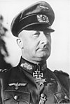 A man wearing a military uniform and peaked cap with two military orders at the front of his uniform collar.