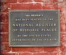 Sign on a brick wall describing a national historic landmark.