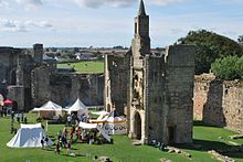 A crowd of people gathered near a tent within the castle