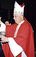 Bishop Alejandro Goic is shown wearing a red chasuble and a white miter