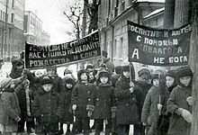 black and white photograph of children marching with anti-religious banners in Russian