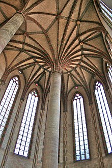 Arched church ceiling, with tall stained-glass windows