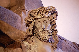 Photograph of a Christ on the cross with only his head crowned with thorns and his eyes closed.