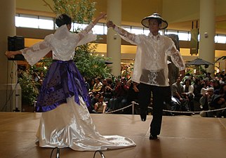 Dancers performing Jota Manileña, the man is wearing a barong tagalog with a salakot