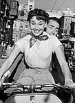 Hepburn wearing a blouse and silk scarf Roman Holiday (1953)