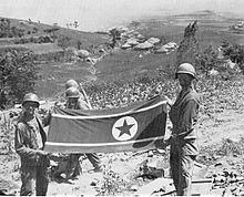 Soldiers hold a North Korean flag