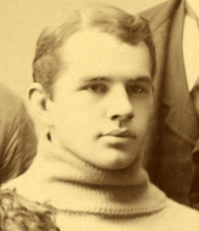 A sepia picture of a young man in a sweater with a "Y"