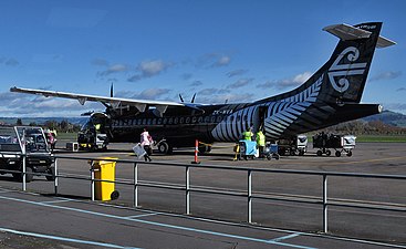 An Air New Zealand ATR 72-600 with a stylised koru on the tail and otherwise painted in all black livery with a silver fern on the fuselage