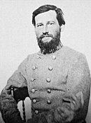 Black and white photo shows a young bearded man in a gray military uniform.