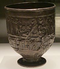 A tarnished silver cup decorated with figures