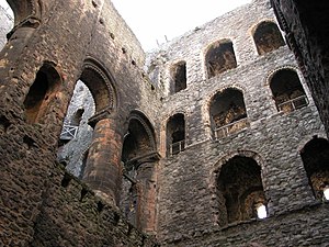 The interior of Rochester Castle, showing galleries in the interior walls and an arcade dividing the great hall.