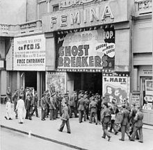 Black-and-white photograph of uniformed soldiers entering a cinema