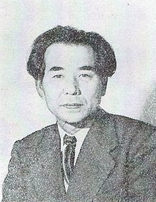Black and white image of a Japanese man wearing a suit