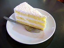 A slice of a layered coconut cake