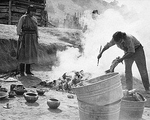 María and Julián Martinez pit firing blackware pottery at P'ohwhóge Owingeh (San Ildefonso Pueblo), New Mexico (c.1920)