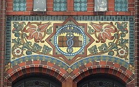 Über der Eingangsloggia rechts: Hermesstab als Symbol des Handels