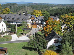 Timber-framed farm estate with the Ore Mountains in the background