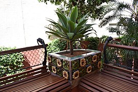 Planter with flower tiles and sunflower leaves