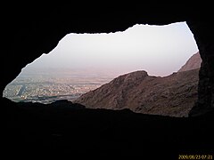 inside small cave; in front of cave is kermanshah city