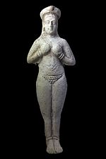 Stone figurine of a female clutching her breasts