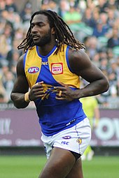 Male athlete with dreadlocks in an Australian rules football game
