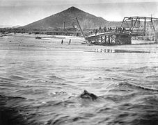 A wrecked bridge along the Santa Cruz during the flood of 1915. "A" Mountain is in the background.