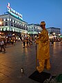 A Street artist at Puerta del Sol and the Tio Pepe Neon Advertisement photographed at Sunset.