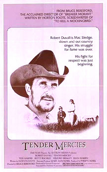 A movie poster with a large picture of a bearded man wearing a cowboy hat, suspended in the background of a photo of a much smaller scaled woman and young boy talking in a field. A tagline beside the man reads "Robert Duvall is Mac Sledge, down and out country singer. His struggle for fame was over. His fight for respect was just beginning." At the bottom, the words "Tender Mercies" appear, along with much smaller credits text. The top of the poster includes additional promotional text.