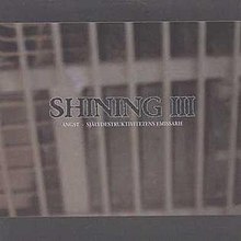 A monochrome image of metals bars like those of a jail cell or security bars over a window. The text "Shining III" is overlayed in the center in a large font with a subheading of "Angst, självdestruktivitetens emissarie" centered below.