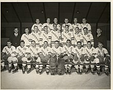 Black and white photo of hockey team, two rows standing behind one row seated
