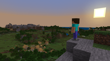 The default player skin, Steve, stands on a cliffside overlooking a village in a forest. In the distance, there is a small mountain range. The sun is setting to the right, making the sky turn pink and blue.