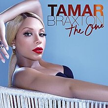 A blonde woman sitting on a chair and posing with her arm over her head. The words "Tamar Braxton" are included in all capital letters and the words "The One" are in a cursive font.