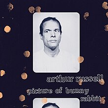Black and white photos of Russell on a blue background with the photos and background having drops of gold paint on them