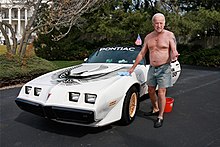 Shirtless man washing a car by hand on the White House driveway