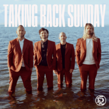 The members of Taking Back Sunday standing in knee-high water wearing brown suits.