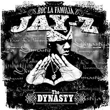 A grayscale photo of Jay-Z doing his signature "diamond" hand gesture. He is wearing a bandana and turns his head away. The photo, which imitates the brush-stroke aesthetics, is overlaid with the word "dynasty", written in a cursive font in various languages. The text "ROC LA FAMILIA" and the bigger text "JAY-Z" underneath it are placed at the top of the cover; the text "The DYNASTY" is located at the bottom.