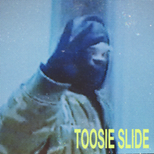 Drake in a balaclava mask, depicted on footage from a security camera and seen on a CRT monitor. On the bottom-right, there is written "TOOSIE SLIDE" in light yellow and typed in Helvetica.