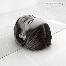 On a table, a head of a person slowly creeps up over a mirror that has it cut out to fit the head. Both the band's name and album title is underlined on the top right with the band's name written in uppercase.