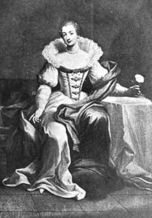 An image of Bridget Paston, Edward Coke's first wife. She is sitting next to a table covered in white cloth, on which she rests her arm, and is wearing a white dress with a corset, a long skirt and a wide ruff around the neck and shoulders.