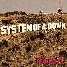 Cover features the words "System of a Down" in place of the Hollywood sign