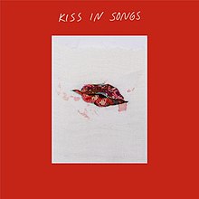 An embroidered design of a pair of red lips, appears on a white rectangle surrounded by a red border and the song's title "Kiss in Songs".